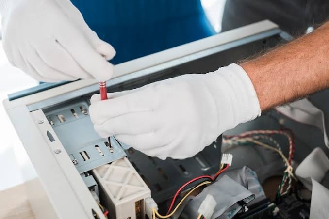 Abilene TX freezer repair technician working inside an appliance panel